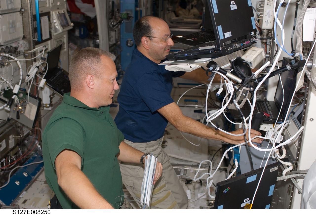 S127-E-008250 (23 July 2009) --- Astronauts Mark Polansky (right) STS-127 commander; and Dooug Hurley, pilot, are pictured in the Japaense Experiment Module or Kibo during flight day 9 activities on the International Space Station.
