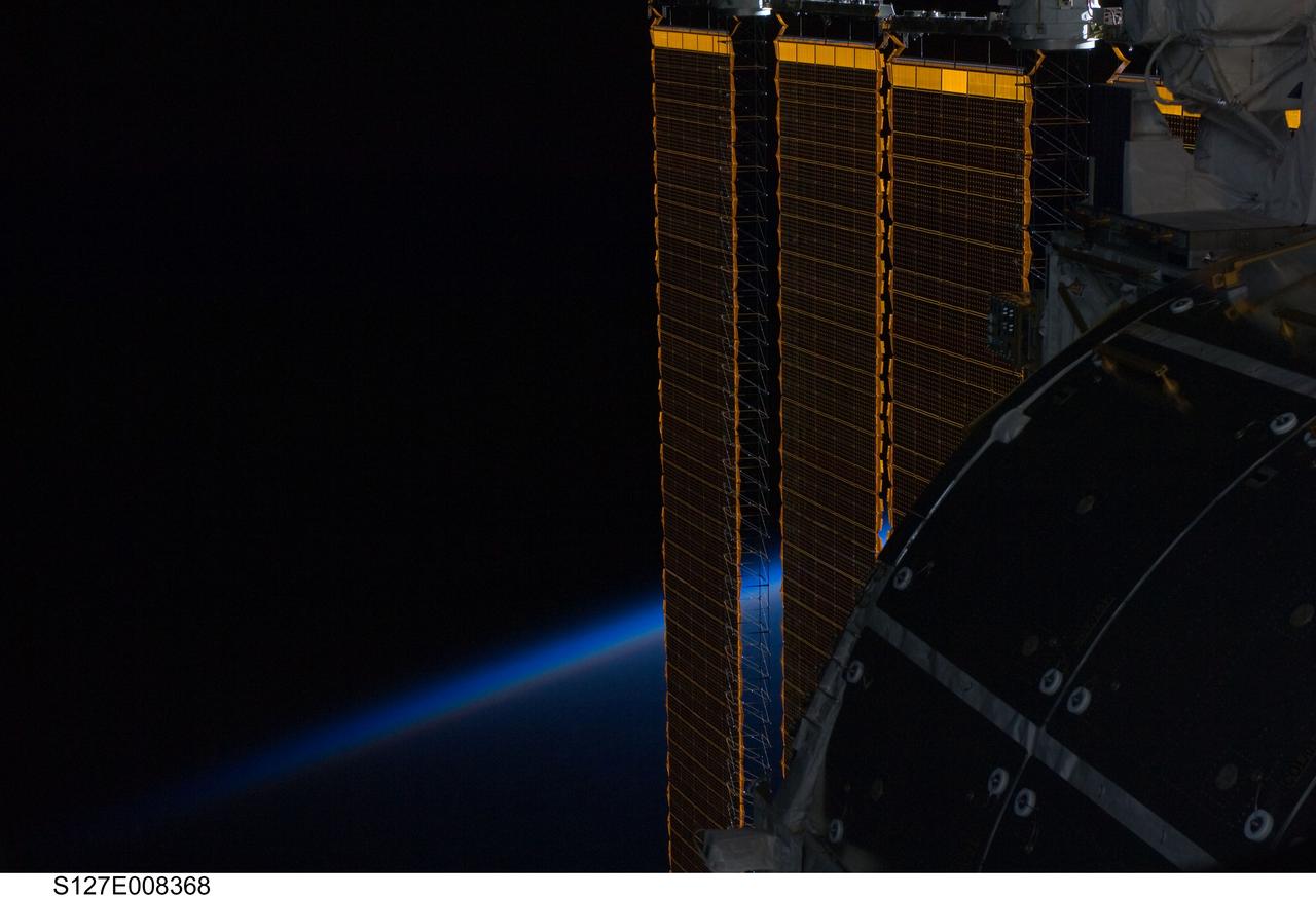 S127-E-008368 (24 July 2009) --- While astronauts Tom Marshburn and Christopher Cassidy (both out of frame), made their spacewalk on July 24, the two mission specialists and the crews of STS-127 and the International Space Station's Expedition 20, were able to enjoy scenes such as this one of one of the orbital outpost's solar panels intersecting Earth's horizon. Eleven astronauts and cosmonauts remained inside the International Space Station and the shuttle to which it was docked, while the two suited astronauts continued work on the orbital outpost.