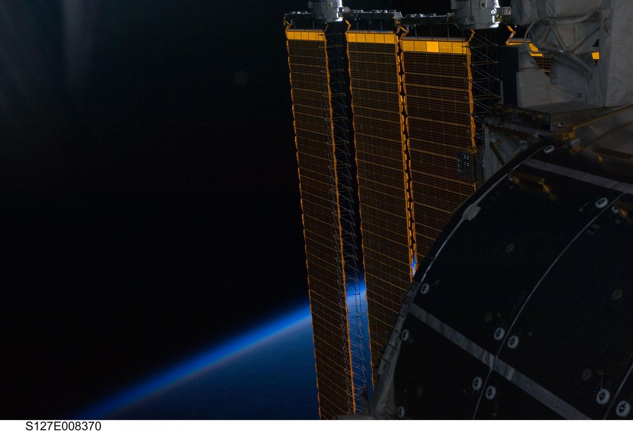 S127-E-008370 (24 July 2009) --- While astronauts Tom Marshburn and Christopher Cassidy (both out of frame), made their spacewalk on July 24, the two mission specialists and the crews of STS-127 and the International Space Station's Expedition 20, were able to enjoy scenes such as this one of one of the orbital outpost's solar panels intersecting Earth's horizon. Eleven astronauts and cosmonauts remained inside the International Space Station and the shuttle to which it was docked, while the two suited astronauts continued work on the orbital outpost.