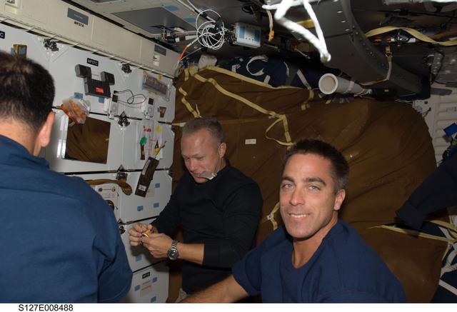 NASA image: STS-127 Crewmembers enjoy meal in the FWD MDDK during Joint Operations
