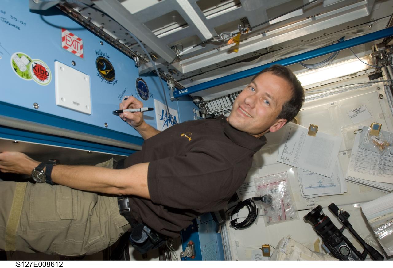 S127-E-008612 (25 July 2009) --- Flight day 11 activities for the joint shuttle-station crews included the traditional autographing of the station. Astronaut Tom Marshburn, STS-127 mission specialist,  has the pen in this frame.