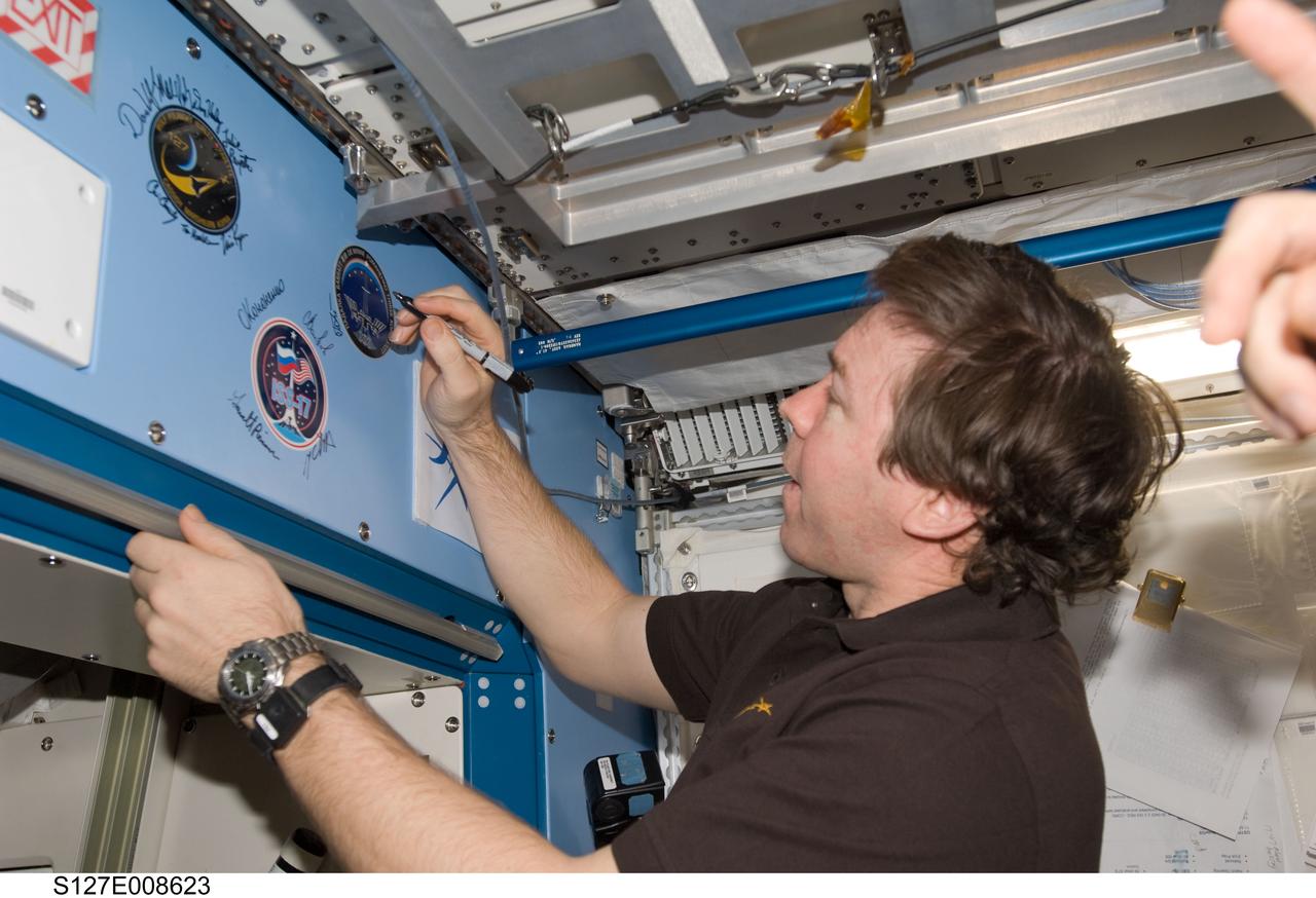 S127-E-008623 (25 July 2009) --- Flight day 11 activities for the joint shuttle-station crews included the traditional autographing of the station. Astronaut Mike Barratt, Expedition 20 flight engineer, has the pen in this frame. Photo credit: NASA