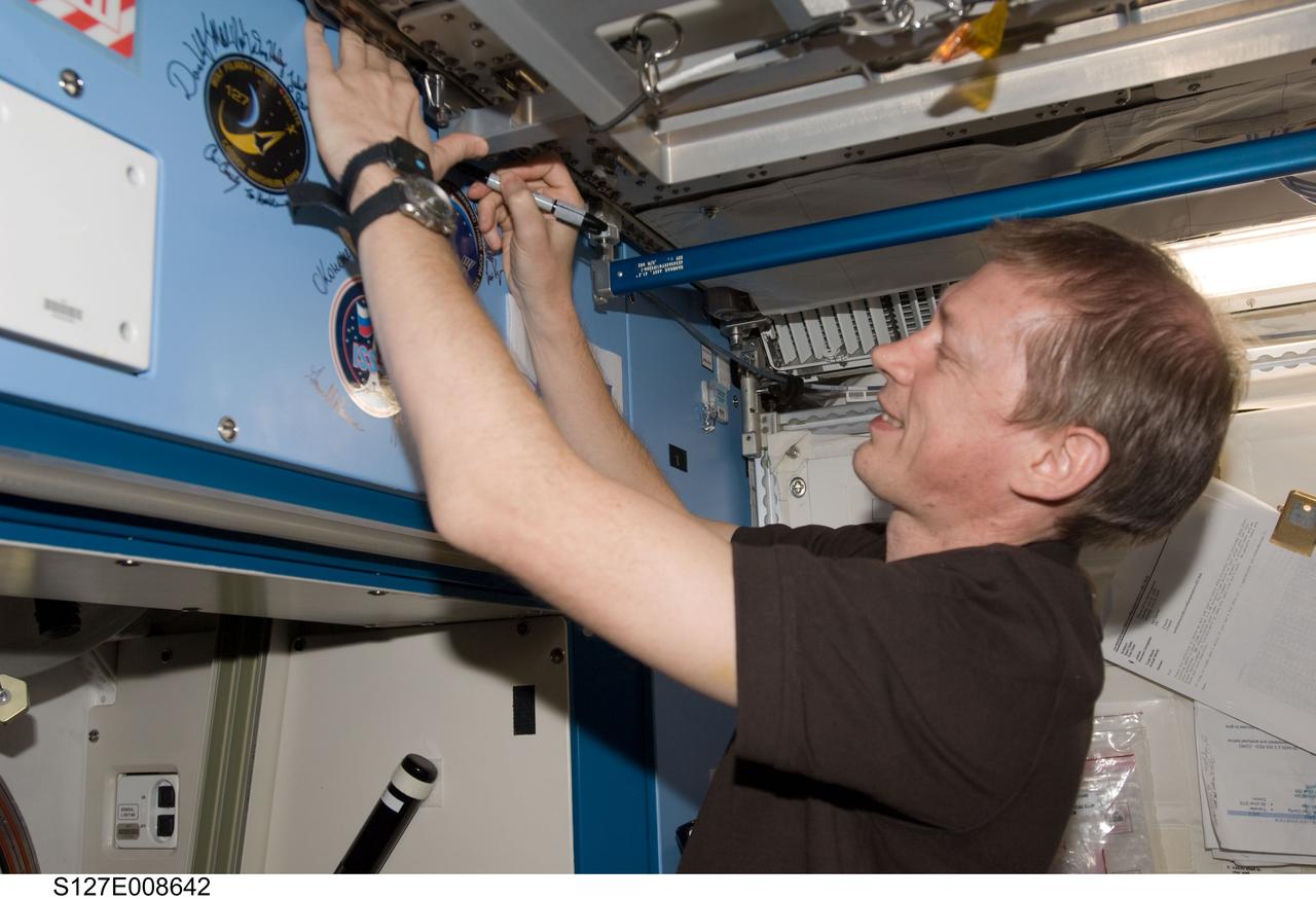 S127-E-008642 (25 July 2009) --- Flight day 11 activities for the joint shuttle-station crews included the traditional autographing of the station. European Space Agency astronaut Frank DeWinne, Expedition 20 flight engineer, has the pen in this frame.