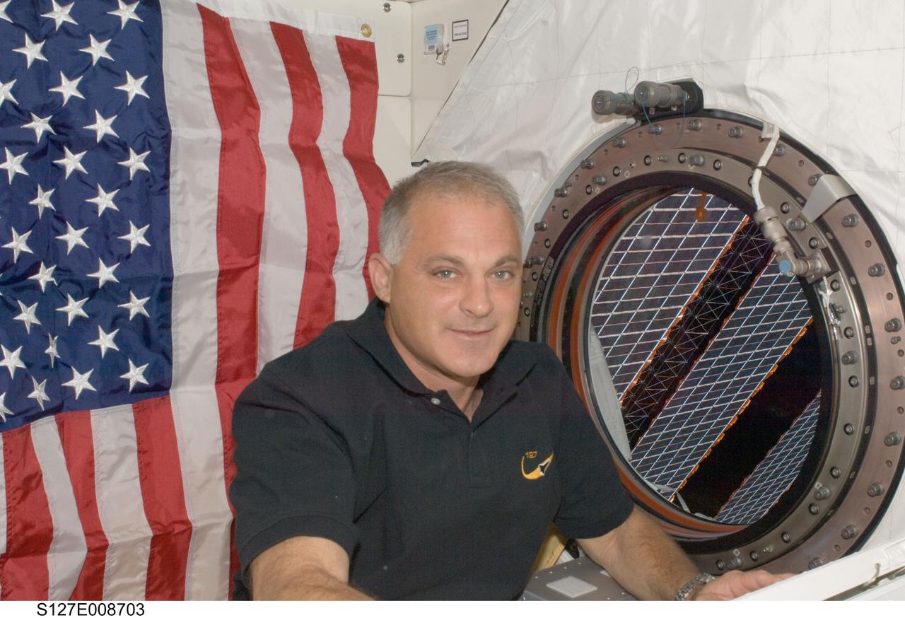 S127-E-008703 (25 July 2009) --- Astronaut Dave Wolf, STS-127 mission specialist, is pictured near a window in the Kibo laboratory of the International Space Station while Space Shuttle Endeavour remains docked with the station.