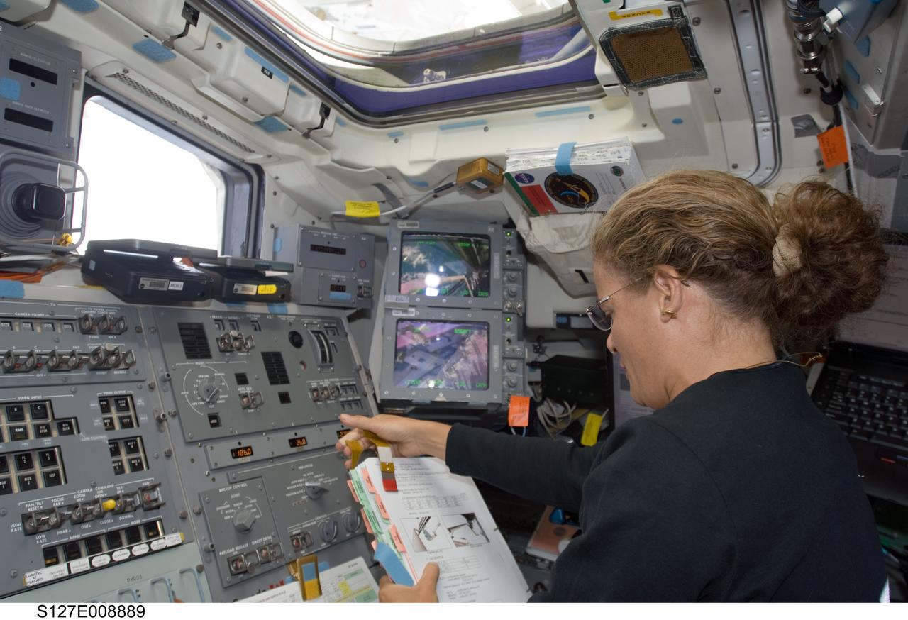 S127-E-008889 (26 July 2009) --- Canadian Space Agency astronaut Julie Payette, STS-127 mission specialist, looks over a checklist on the aft flight deck of Space Shuttle Endeavour while docked with the International Space Station.