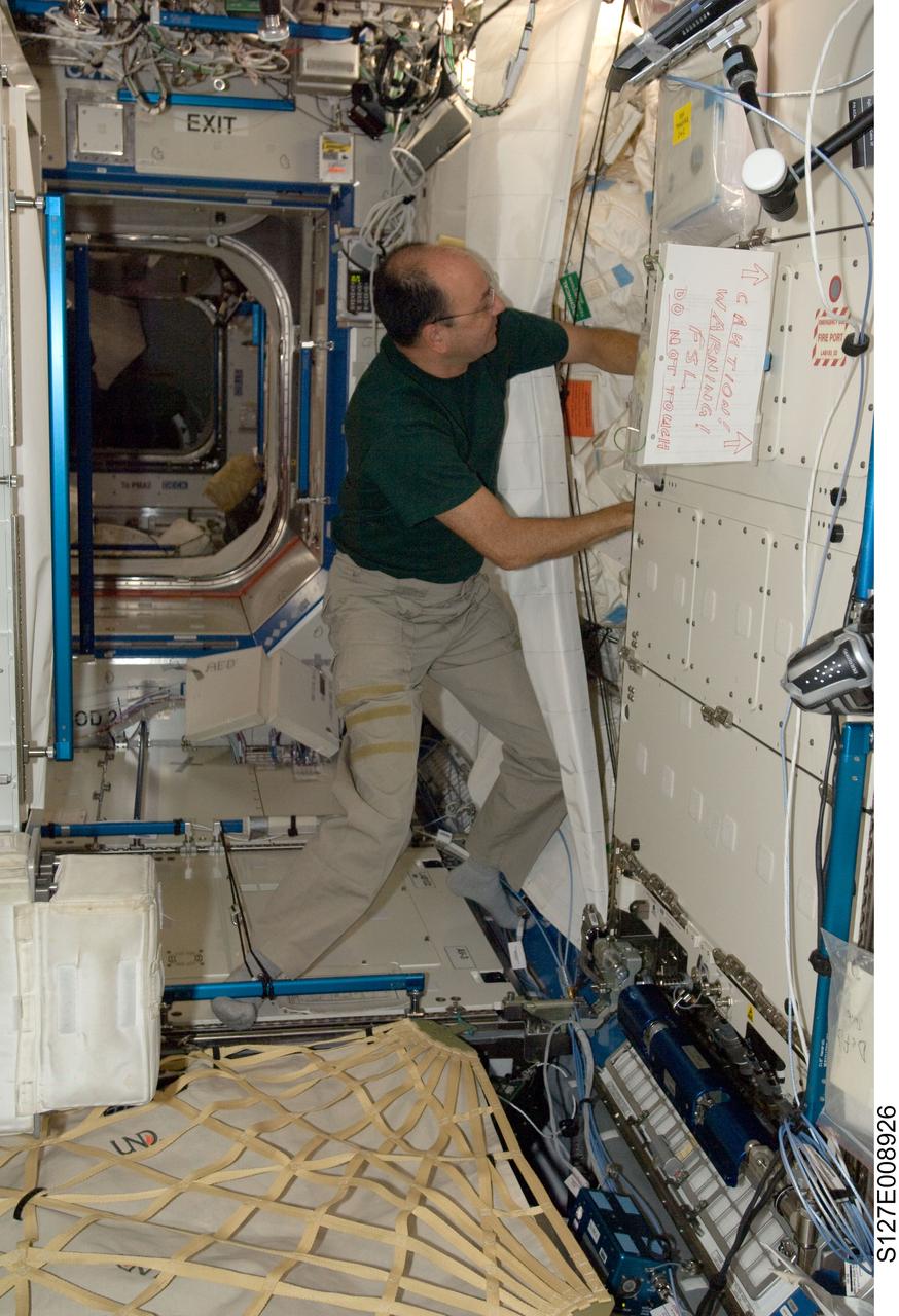 S127-E-008926 (26 July 2009) --- Astronaut Mark Polansky, STS-127 commander, works in the Destiny laboratory of the International Space Station while Space Shuttle Endeavour remains docked with the station.