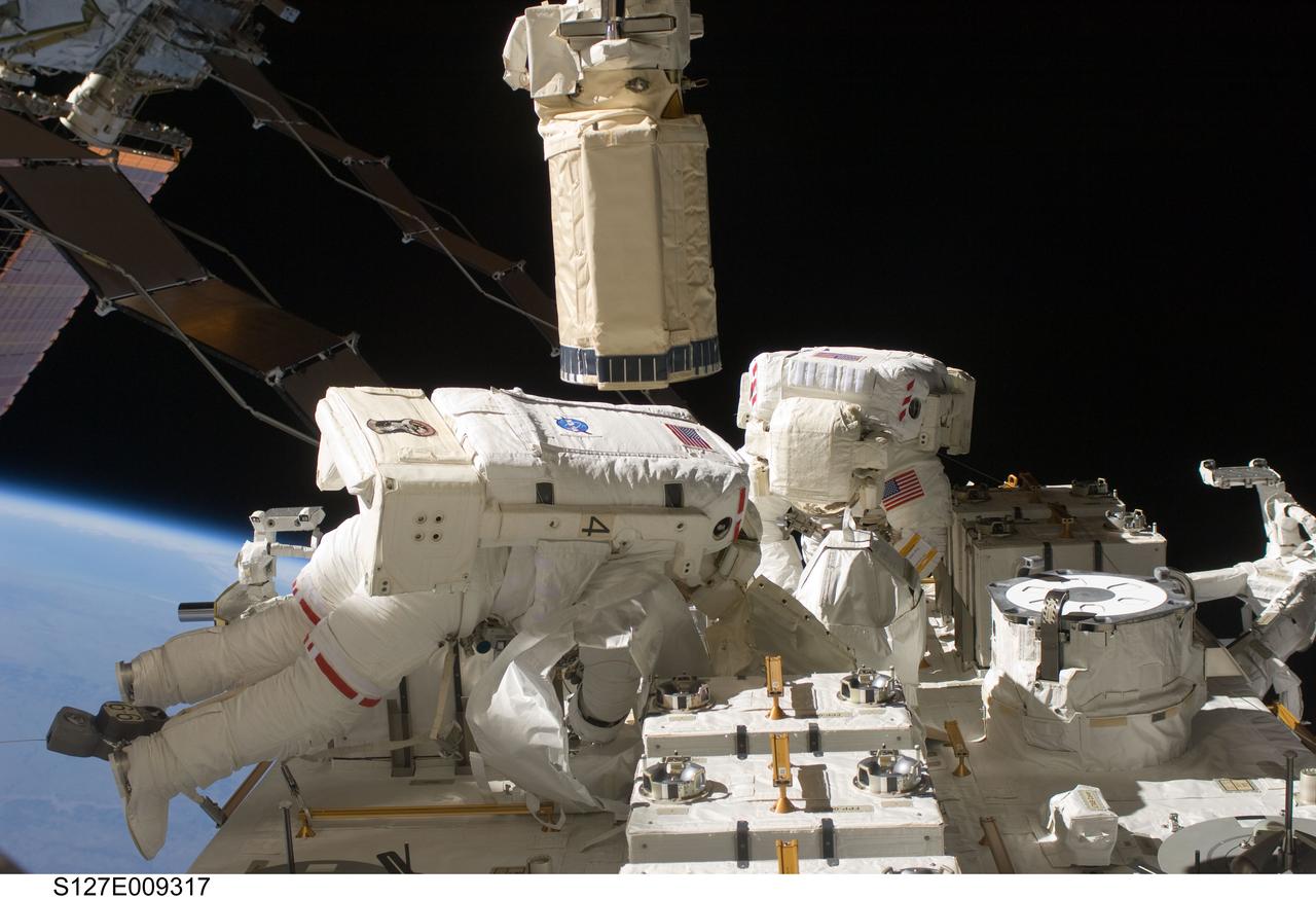 S127-E-009317 (27 July 2009) --- Astronauts Tom Marshburn (left) and Christopher Cassidy, both STS-127 mission specialists, participate in the mission's fifth and final session of extravehicular activity (EVA) as construction and maintenance continue on the International Space Station. During the four-hour, 54-minute spacewalk, Marshburn and Cassidy secured multi-layer insulation around the Special Purpose Dexterous Manipulator known as Dextre, split out power channels for two space station Control Moment Gyroscopes, installed video cameras on the front and back of the new Japanese Exposed Facility and performed a number of “get ahead” tasks, including tying down some cables and installing handrails and a portable foot restraint to aid future spacewalkers.