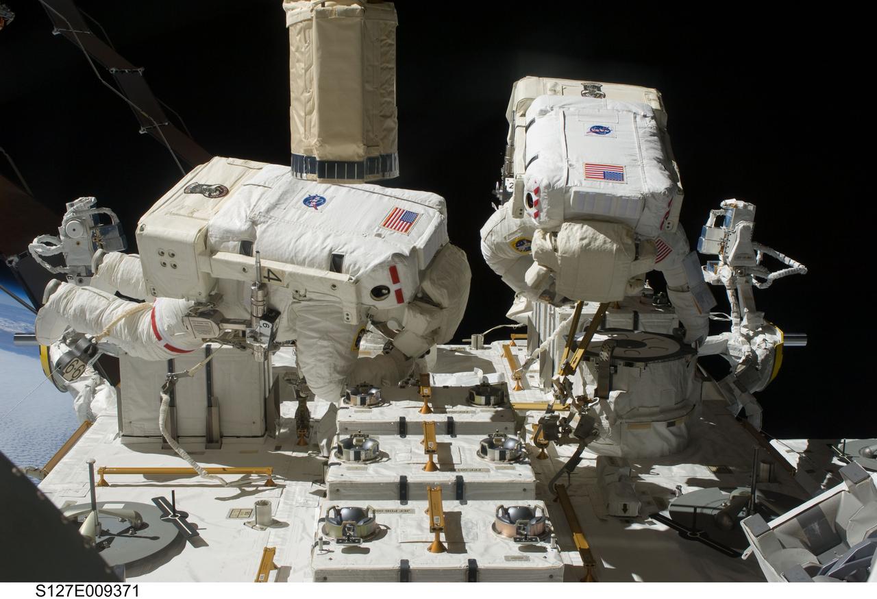 S127-E-009371 (27 July 2009) --- Astronauts Tom Marshburn (left) and Christopher Cassidy, both STS-127 mission specialists, participate in the mission's fifth and final session of extravehicular activity (EVA) as construction and maintenance continue on the International Space Station. During the four-hour, 54-minute spacewalk, Marshburn and Cassidy secured multi-layer insulation around the Special Purpose Dexterous Manipulator known as Dextre, split out power channels for two space station Control Moment Gyroscopes, installed video cameras on the front and back of the new Japanese Exposed Facility and performed a number of “get ahead” tasks, including tying down some cables and installing handrails and a portable foot restraint to aid future spacewalkers.