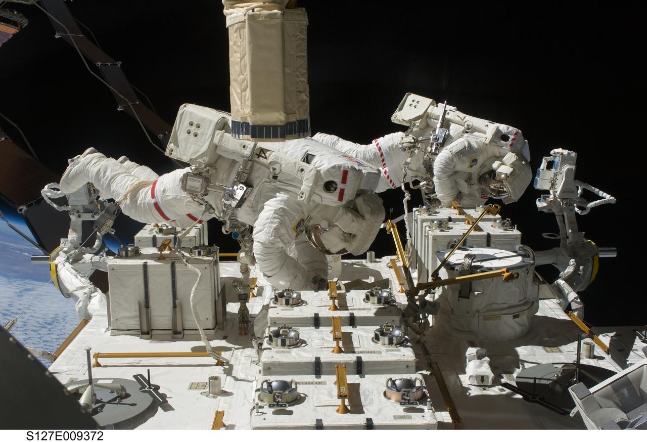 S127-E-009372 (27 July 2009) --- Astronauts Tom Marshburn (left) and Christopher Cassidy, both STS-127 mission specialists, participate in the mission's fifth and final session of extravehicular activity (EVA) as construction and maintenance continue on the International Space Station. During the four-hour, 54-minute spacewalk, Marshburn and Cassidy secured multi-layer insulation around the Special Purpose Dexterous Manipulator known as Dextre, split out power channels for two space station Control Moment Gyroscopes, installed video cameras on the front and back of the new Japanese Exposed Facility and performed a number of “get ahead” tasks, including tying down some cables and installing handrails and a portable foot restraint to aid future spacewalkers.