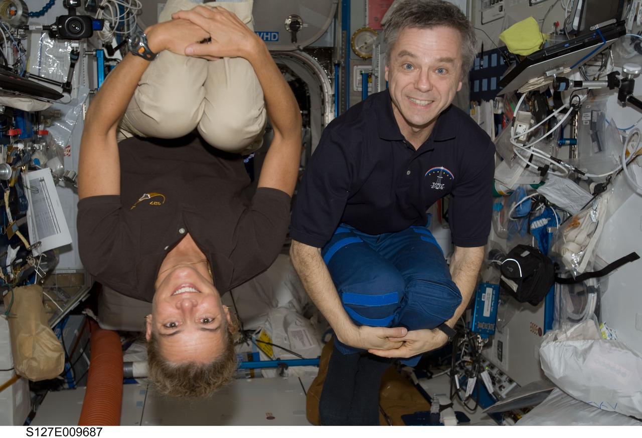 S127-E-009687 (28 July 2009) --- Canadian Space Agency astronauts Julie Payette, STS-127 mission specialist; and Robert Thirsk, Expedition 20 flight engineer, pose for a photo in the Destiny laboratory of the International Space Station while Space Shuttle Endeavour remains docked with the station.