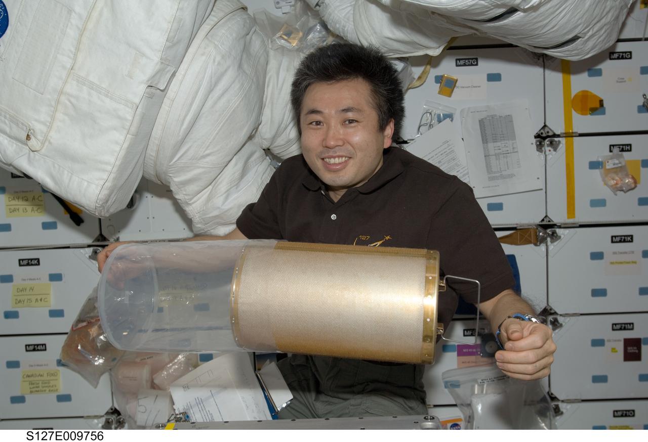S127-E-009756 (28 July 2009) --- Japan Aerospace Exploration Agency (JAXA) astronaut Koichi Wakata, STS-127 mission specialist, is pictured near a lithium hydroxide (LiOH) canister floating freely on the middeck of Space Shuttle Endeavour during flight day 14 activities.