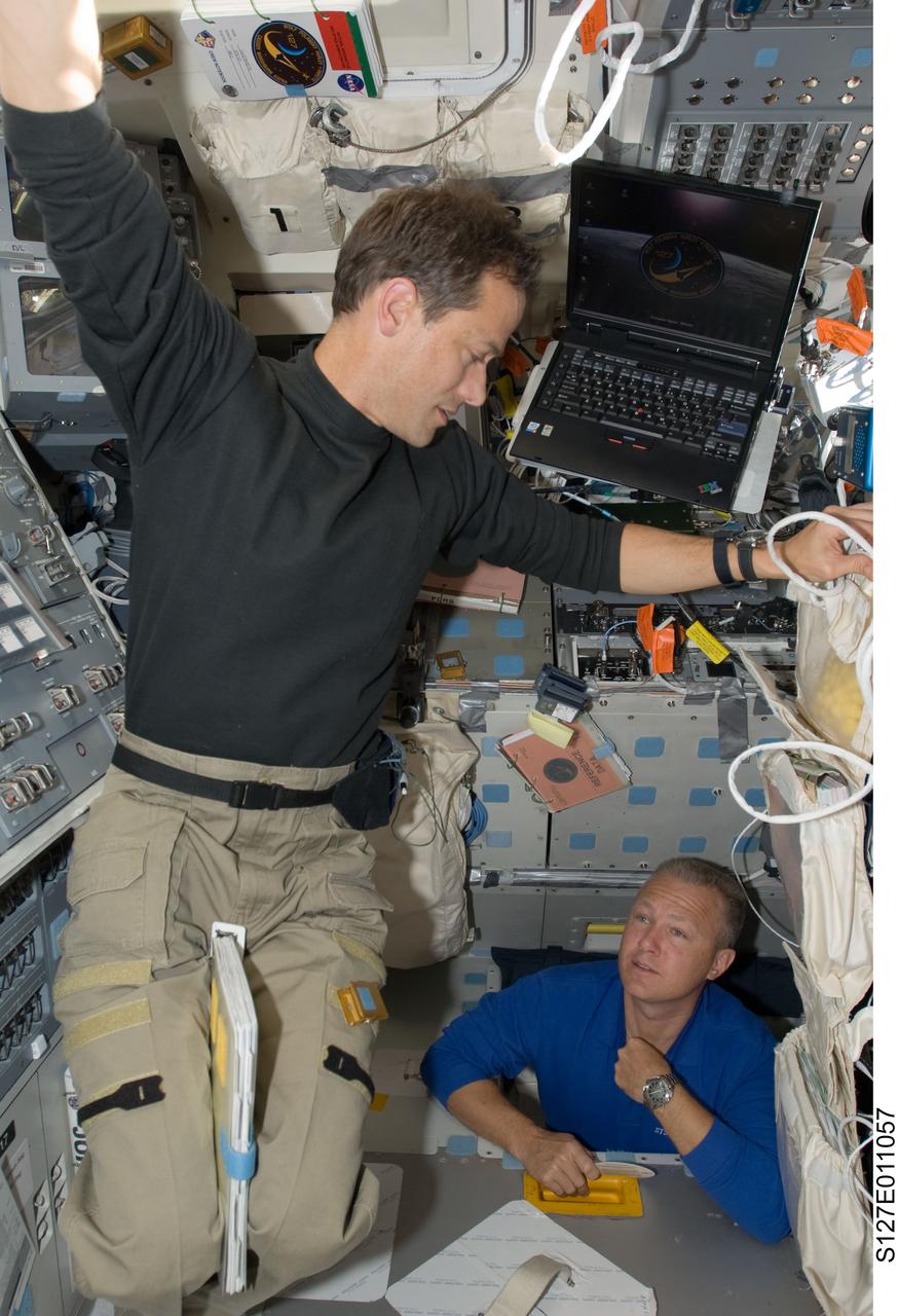 S127-E-011057 (28 July 2009) --- Astronauts Tom Marshburn (left), STS-127 mission specialist; and Doug Hurley, pilot, are pictured on the aft flight deck of Space Shuttle Endeavour during flight day 14 activities.