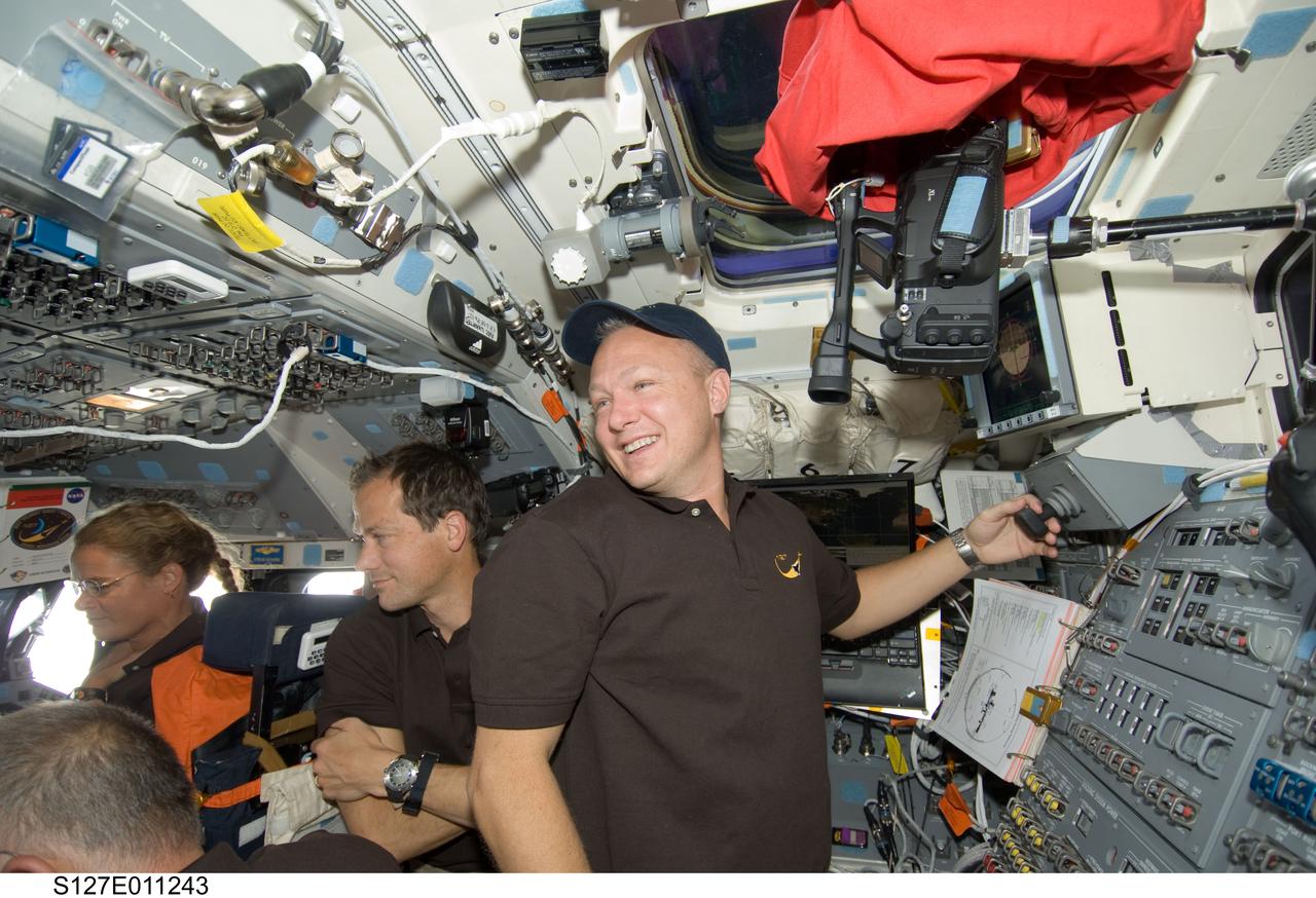 S127-E-011243 (28 July 2009) --- Astronauts Doug Hurley (right), STS-127 pilot; Tom Marshburn, and Canadian Space Agency’s Julie Payette, both mission specialists, are pictured on the flight deck of Space Shuttle Endeavour during flight day 14 activities.