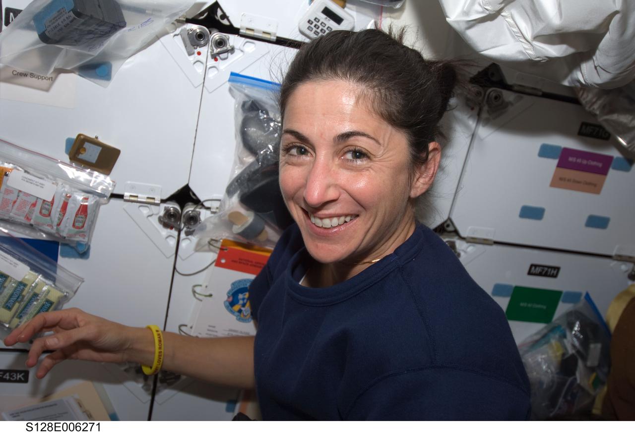 S128-E-006271 (29 Aug. 2009) --- Astronaut Nicole Stott, STS-128 mission specialist, smiles for a photo on the middeck of Space Shuttle Discovery during flight day two activities.