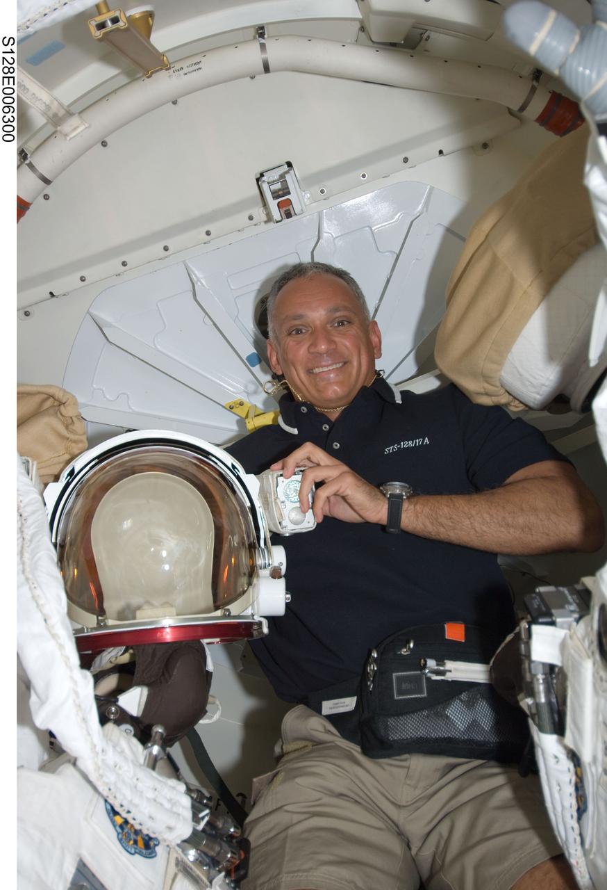 S128-E-006300 (29 Aug. 2009) --- Astronaut John “Danny” Olivas, STS-128 mission specialist, poses for a photo while holding an Extravehicular Mobility Unit (EMU) spacesuit helmet on the Space Shuttle Discovery during flight day two activities.