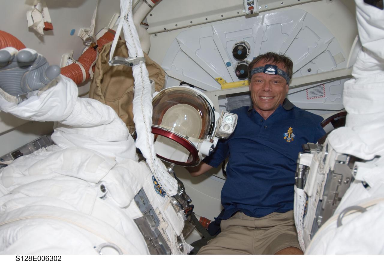 S128-E-006302 (29 Aug. 2009) --- European Space Agency astronaut Christer Fuglesang, STS-128 mission specialist, is pictured between two Extravehicular Mobility Unit (EMU) spacesuits on the Space Shuttle Discovery during flight day two activities.