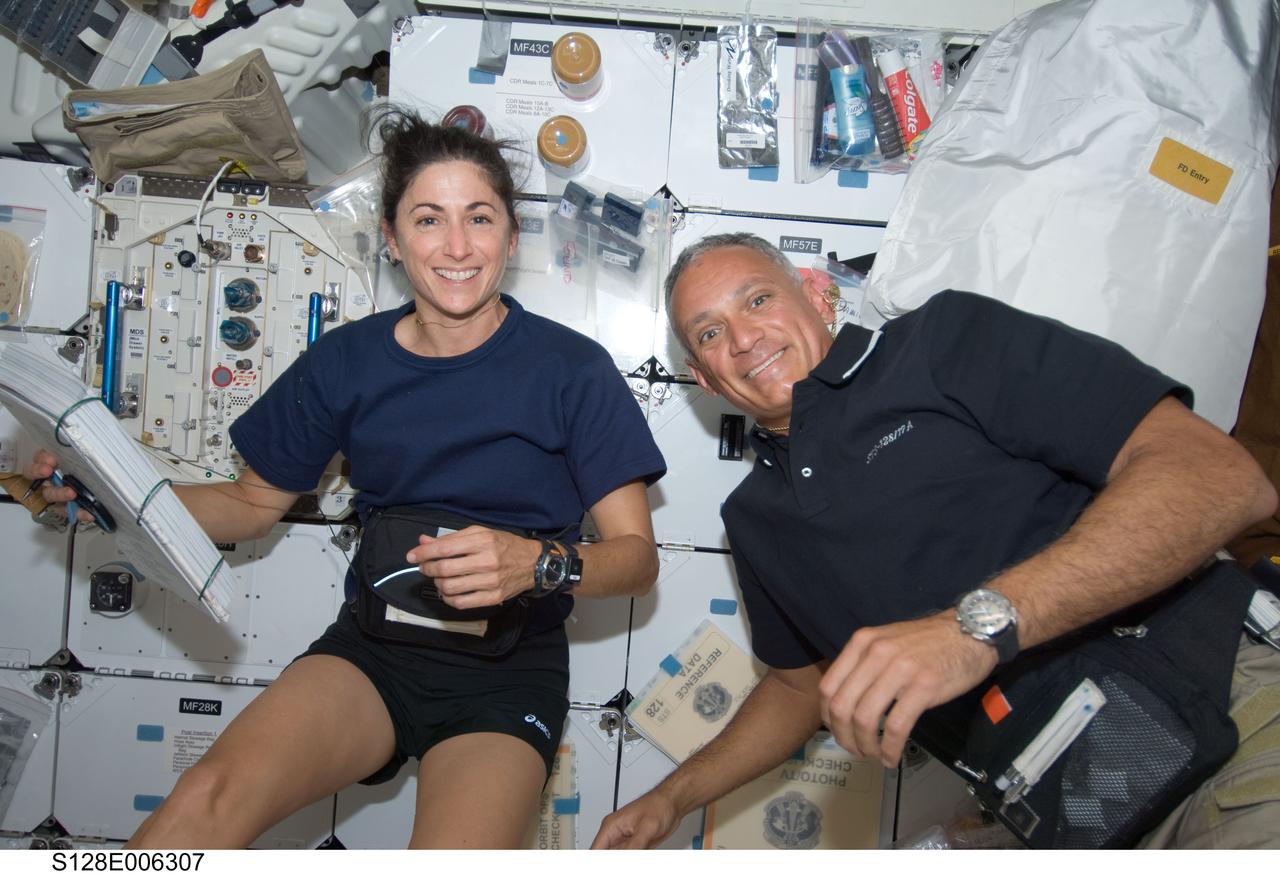 S128-E-006307 (29 Aug. 2009) --- Astronaut Nicole Stott and John “Danny” Olivas, both STS-128 mission specialists, smile for a photo on Space Shuttle Discovery’s middeck during flight day two activities.