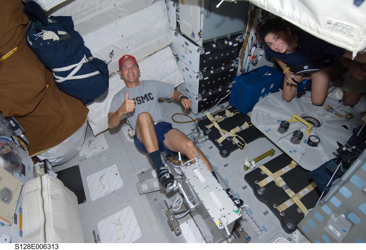 S128-E-006313 (29 Aug. 2009) --- Astronaut Rick Sturckow, STS-128 commander, gives a “thumbs-up” signal while exercising on a bicycle ergometer on the middeck of the Earth-orbiting Space Shuttle Discovery. Astronaut Nicole Stott, mission specialist, is visible at right.