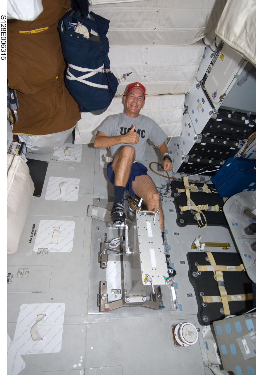 S128-E-006315 (29 Aug. 2009) --- Astronaut Rick Sturckow, STS-128 commander, gives a “thumbs-up” signal while exercising on a bicycle ergometer on the middeck of the Earth-orbiting Space Shuttle Discovery.