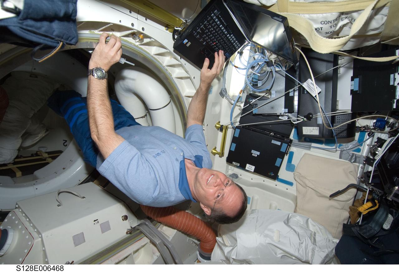 S128-E-006468 (29 Aug. 2009) --- Astronaut Kevin Ford, STS-128 pilot, uses a computer on the middeck of the Earth-orbiting Space Shuttle Discovery during flight day two activities.