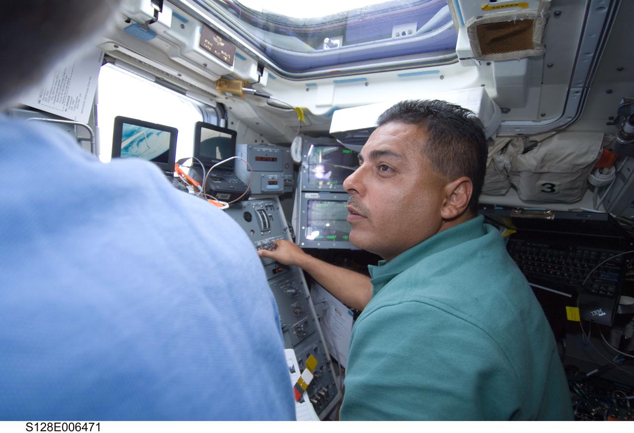 S128-E-006471 (29 Aug. 2009) --- Astronaut Jose Hernandez, STS-128 mission specialist, works controls on the aft flight deck of the Earth-orbiting Space Shuttle Discovery during flight day two activities.
