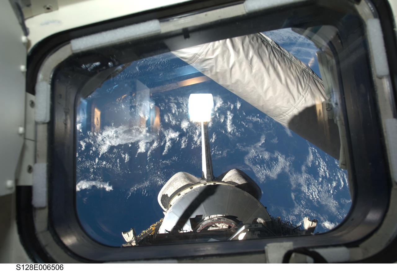 S128-E-006506 (29 Aug. 2009) --- Framed by an aft flight deck window, the Leonardo Multi-Purpose Logistics Module visible in Space Shuttle Discovery's payload bay, vertical stabilizer and orbital maneuvering system (OMS) pods are featured in this image photographed by a STS-128 crew member.