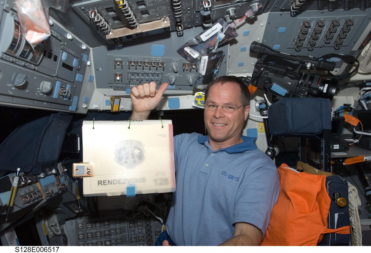 S128-E-006517 (29 Aug. 2009) --- Astronaut Kevin Ford, STS-128 pilot, occupies the pilot’s station on the forward flight deck of Space Shuttle Discovery during flight day two activities. A rendezvous procedure manual floats freely in the foreground.