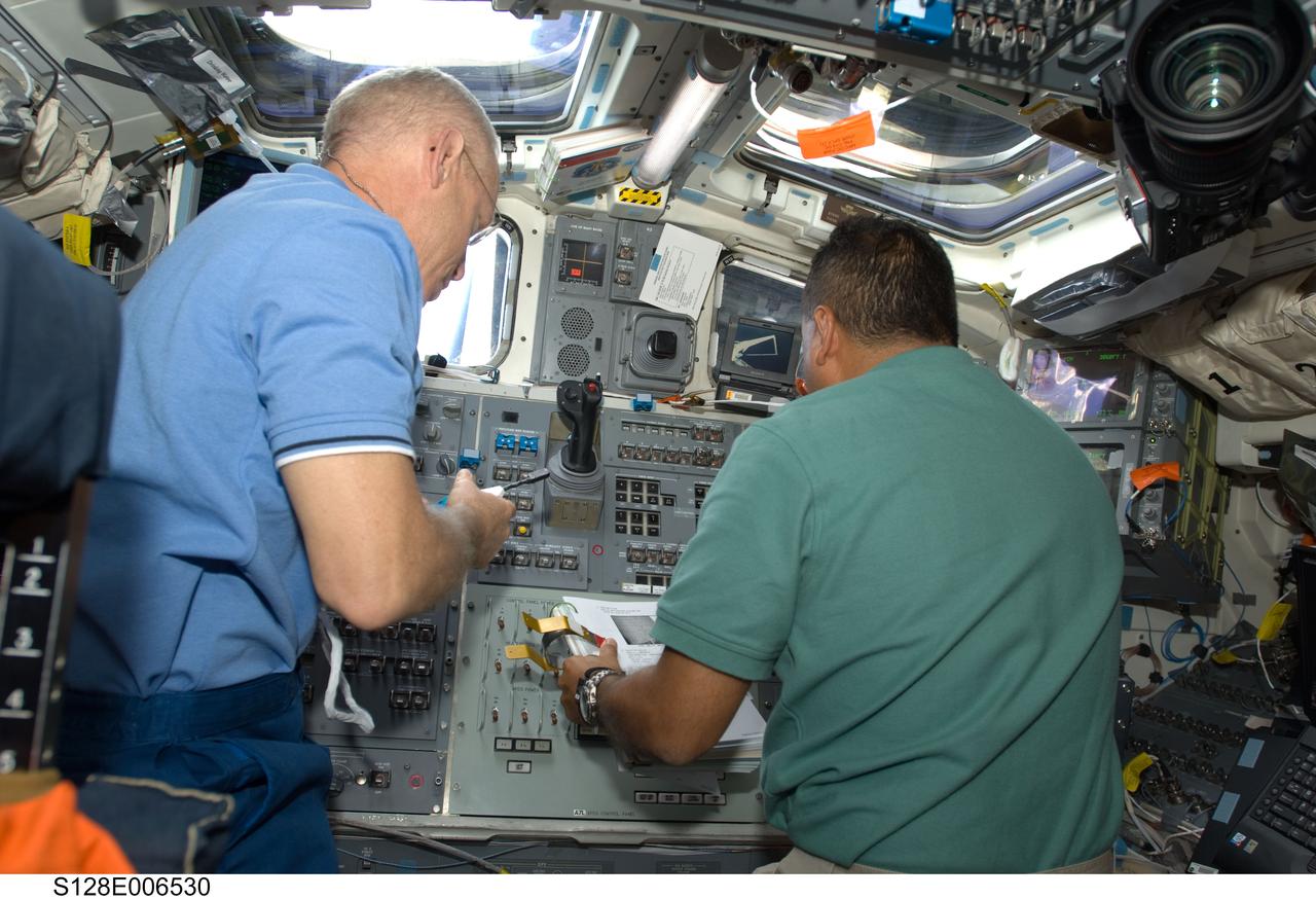 S128-E-006530 (29 Aug. 2009) --- Astronauts Patrick Forrester (left) and Jose Hernandez, both STS-128 mission specialists, work on the aft flight deck of Space Shuttle Discovery during flight day two activities.