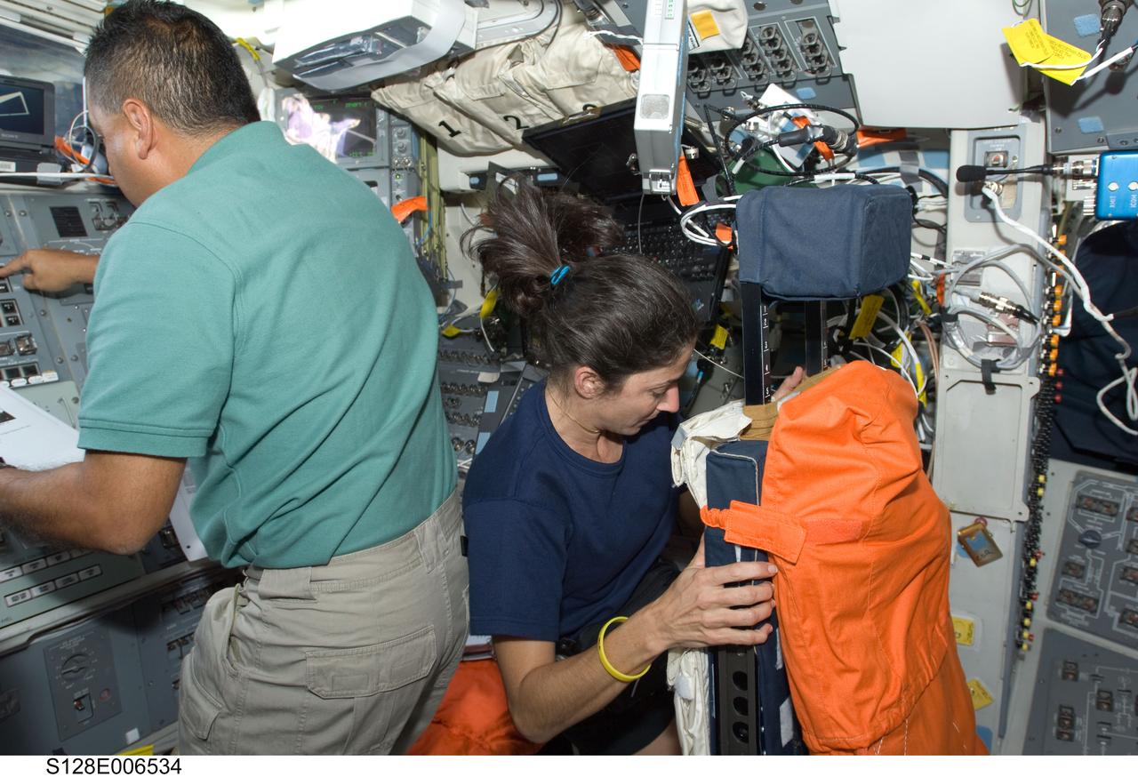 S128-E-006534 (29 Aug. 2009) --- Astronauts Jose Hernandez and Nicole Stott, both STS-128 mission specialists, work on the aft flight deck of Space Shuttle Discovery during flight day two activities.