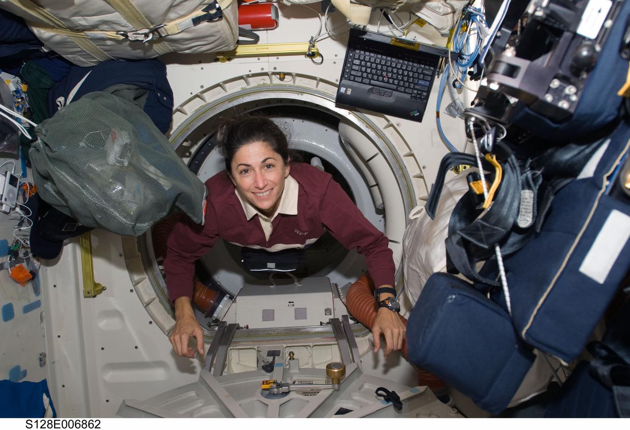 S128-E-006862 (30 Aug. 2009) --- Astronaut Nicole Stott, STS-128 mission specialist, floats through a hatch on the Space Shuttle Discovery during flight day three activities.