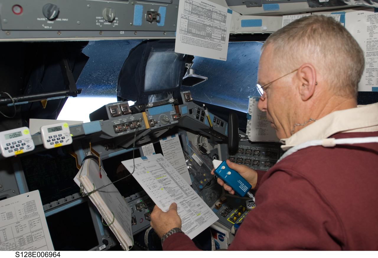 S128-E-006964 (30 Aug. 2009) --- Astronaut Patrick Forrester, STS-128 mission specialist, looks over a checklist while occupying the pilot’s station on the flight deck of Space Shuttle Discovery during flight day three activities.