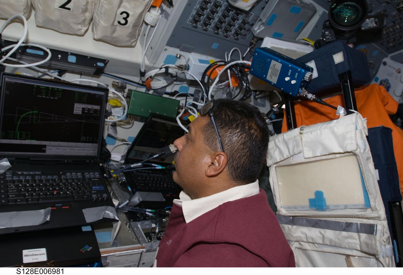 S128-E-006981 (30 Aug. 2009) --- Astronaut Jose Hernandez, STS-128 mission specialist, watches a computer monitor on the flight deck of Space Shuttle Discovery during flight day three activities.