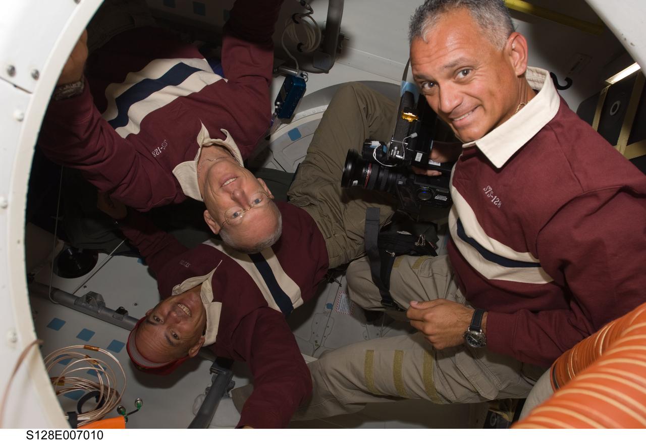 S128-E-007010 (30 Aug. 2009) --- Astronauts Rick Sturckow (bottom), STS-128 commander; John “Danny” Olivas (right) and Patrick Forrester, both mission specialists, are pictured near the hatch on the middeck of Space Shuttle Discovery after docking with the International Space Station. The two spacecraft docked at 7:54 p.m. (CDT), and the Discovery crew entered the orbital outpost at 9:59 p.m. (CDT) on Aug. 30.