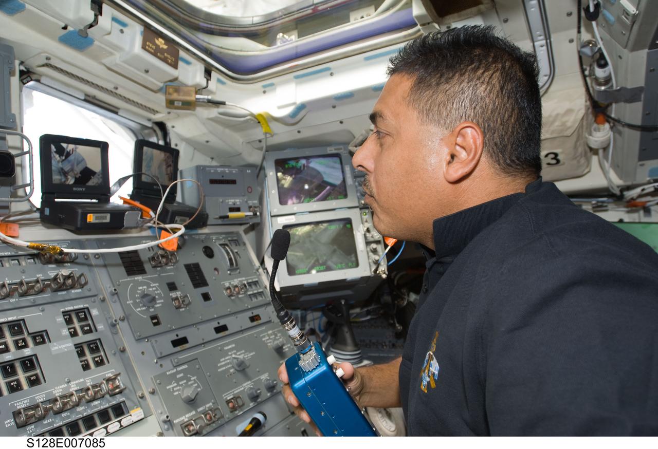 S128-E-007085 (31 Aug. 2009) --- Astronaut Jose Hernandez, STS-128 mission specialist, uses a communication system on the aft flight deck of Space Shuttle Discovery while docked with the International Space Station.