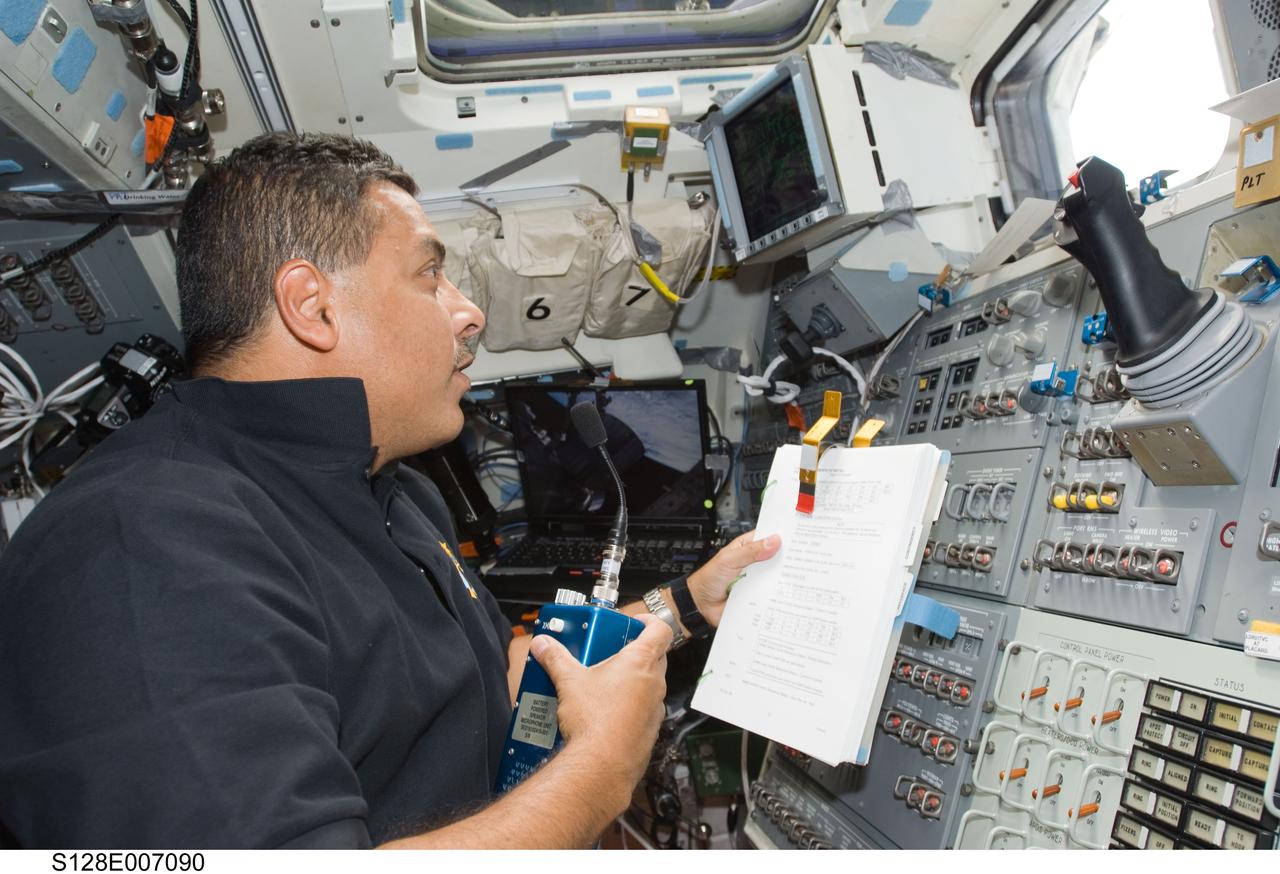 S128-E-007090 (31 Aug. 2009) --- Astronaut Jose Hernandez, STS-128 mission specialist, uses a communication system on the aft flight deck of Space Shuttle Discovery while docked with the International Space Station.