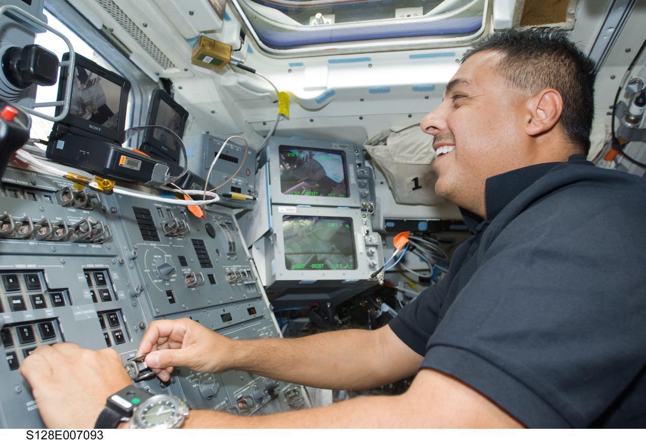 S128-E-007093 (31 Aug. 2009) --- Astronaut Jose Hernandez, STS-128 mission specialist, works controls on the aft flight deck of Space Shuttle Discovery while docked with the International Space Station.