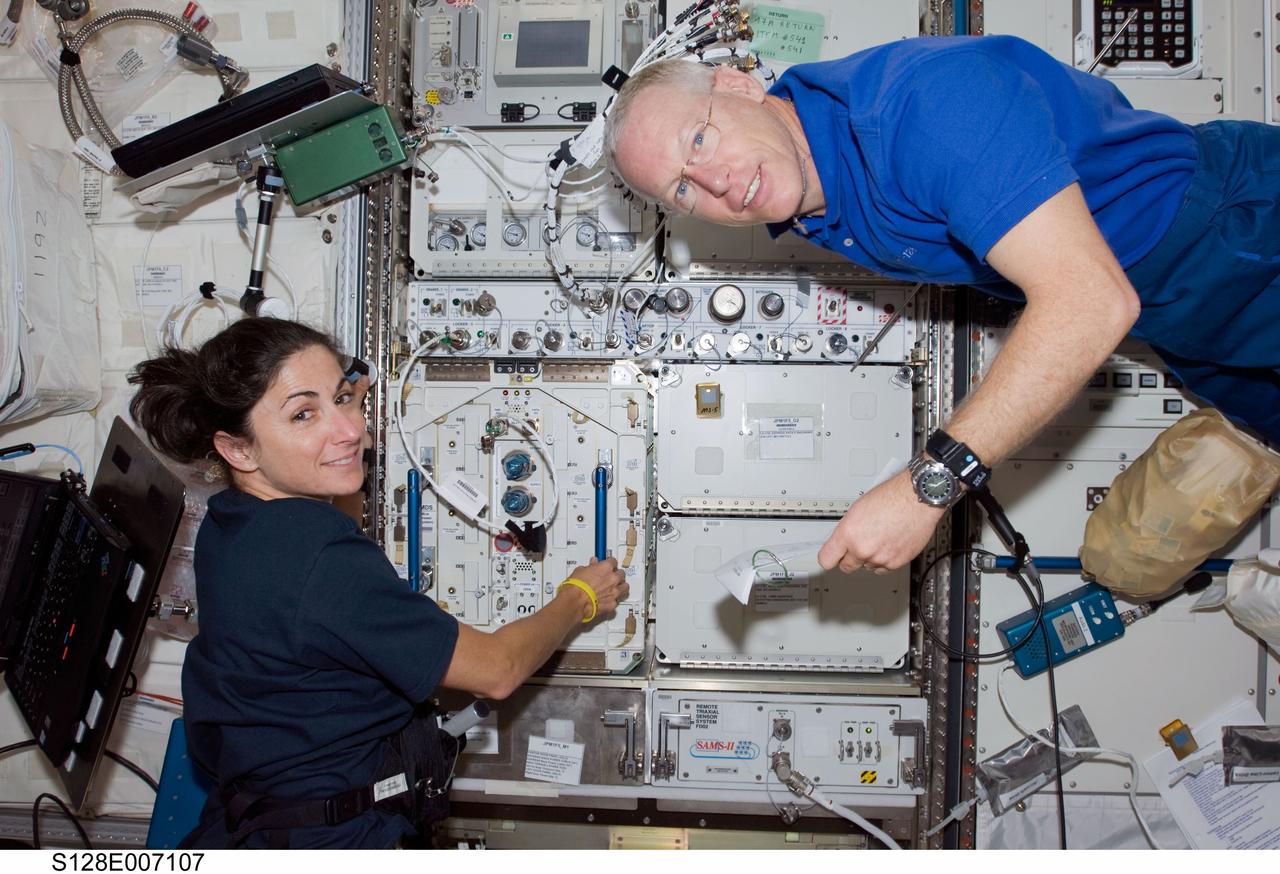S128-E-007107 (31 Aug. 2009) --- Astronauts Nicole Stott, Expedition 20 flight engineer; and Patrick Forrester, STS-128 mission specialist, work in the Kibo laboratory of the International Space Station while Space Shuttle Discovery remains docked to the station.