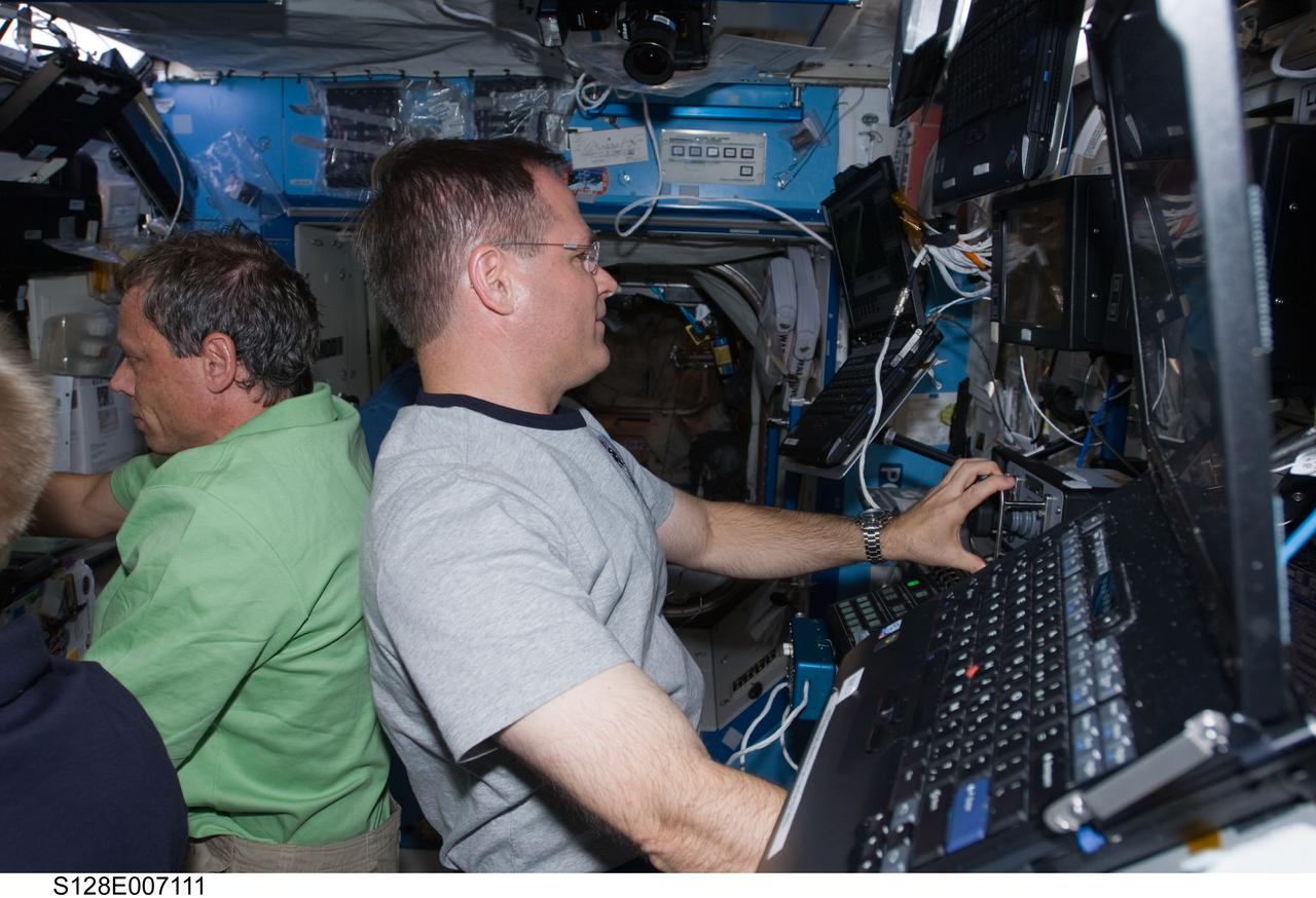 S128-E-007111 (31 Aug. 2009) --- NASA astronaut Kevin Ford (right), STS-128 pilot; and European Space Agency astronaut Christer Fuglesang, mission specialist, work in the Destiny laboratory of the International Space Station while Space Shuttle Discovery remains docked with the station.