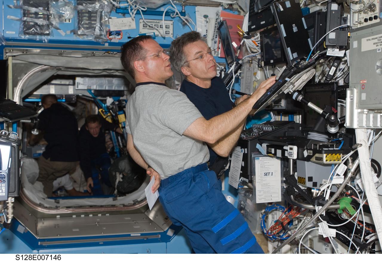 S128-E-007146 (31 Aug. 2009) --- NASA astronaut Kevin Ford (foreground), STS-128 pilot; and Canadian Space Agency astronaut Robert Thirsk, Expedition 20 flight engineer, work in the Destiny laboratory of the International Space Station while Space Shuttle Discovery remains docked with the station.
