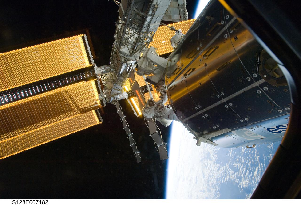 S128-E-007182 (1 Sept. 2009) --- Astronauts John “Danny” Olivas and Nicole Stott (partially obscured at top), both STS-128 mission specialists, participate in the mission's first session of extravehicular activity (EVA) as construction and maintenance continue on the International Space Station. During the six-hour, 35-minute spacewalk, Olivas and Stott removed an empty ammonia tank from the station’s truss and temporarily stowed it on the station’s robotic arm. Olivas and Stott also retrieved the European Technology Exposure Facility (EuTEF) and Materials International Space Station Experiment (MISSE) from the Columbus laboratory module and installed them on Discovery’s payload bay for return. The blackness of space and Earth’s horizon provide the backdrop for the scene.