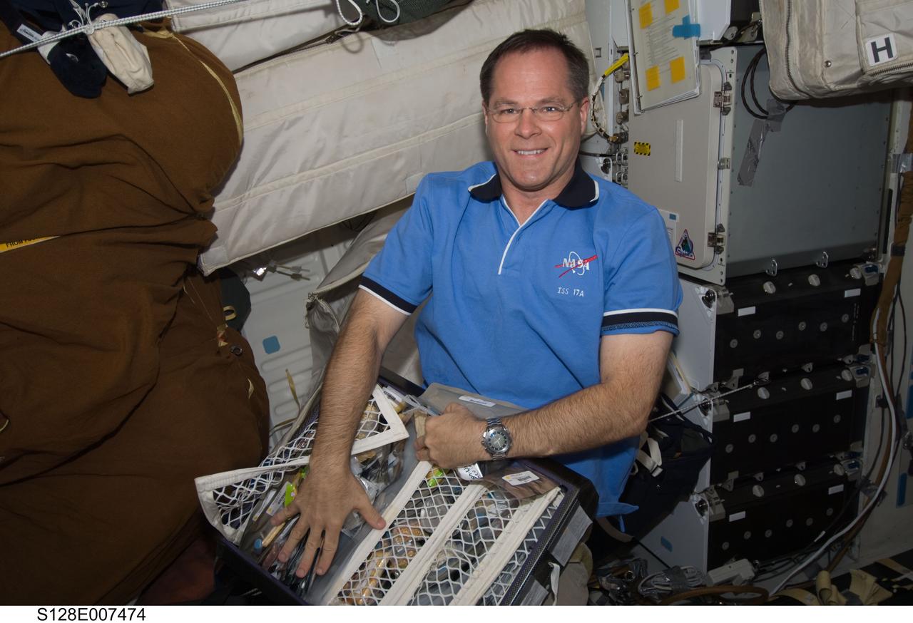 S128-E-007474 (3 Sept. 2009) --- NASA astronaut Kevin Ford, STS-128 pilot, holds a storage bag containing food items on the middeck of Space Shuttle Discovery while docked with the International Space Station.