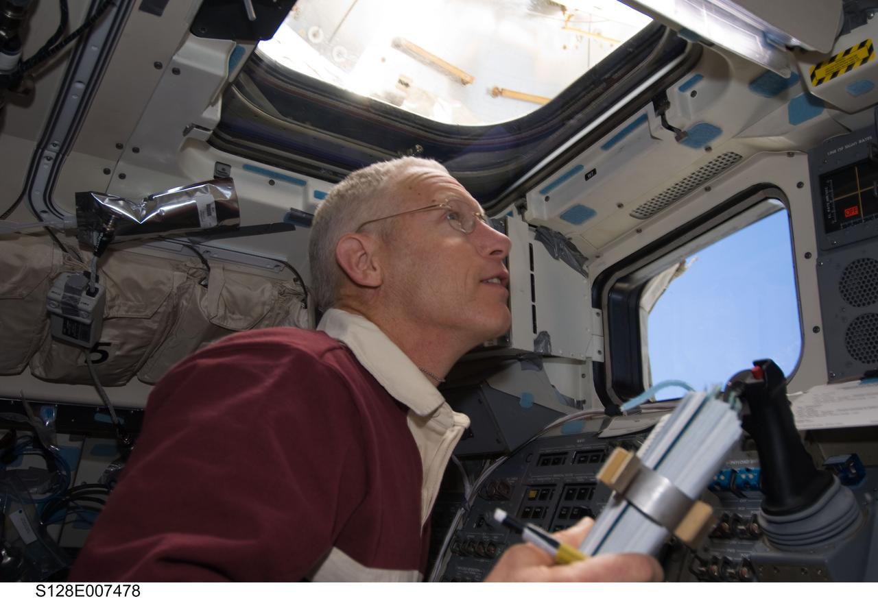 S128-E-007478 (3 Sept. 2009) --- NASA astronaut Patrick Forrester, STS-128 mission specialist, watches his crewmates during the mission’s second spacewalk through an overhead window on the aft flight deck of Space Shuttle Discovery while docked with the International Space Station.
