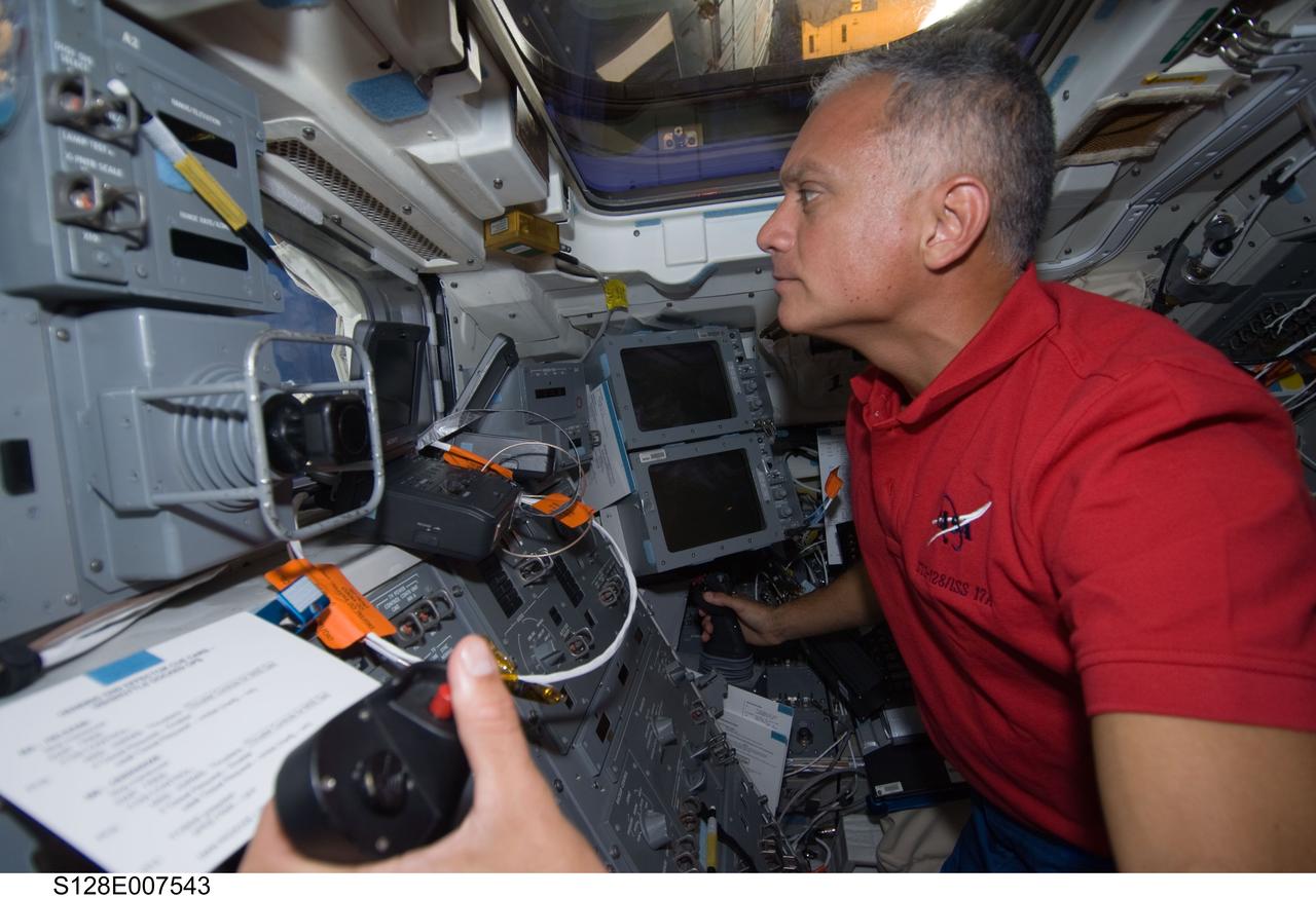 S128-E-007543 (4 Sept. 2009) --- Astronaut John "Danny" Olivas, STS-128 mission specialist, is pictured at the controls on the aft flight deck of the Space Shuttle Discovery while it is docked with the International Space Station. Olivas is scheduled to participate in the third and final STS-128 spacewalk on Sept. 5.  He also took part in the first two sessions of extravehicular activity to perform work on the orbital outpost.