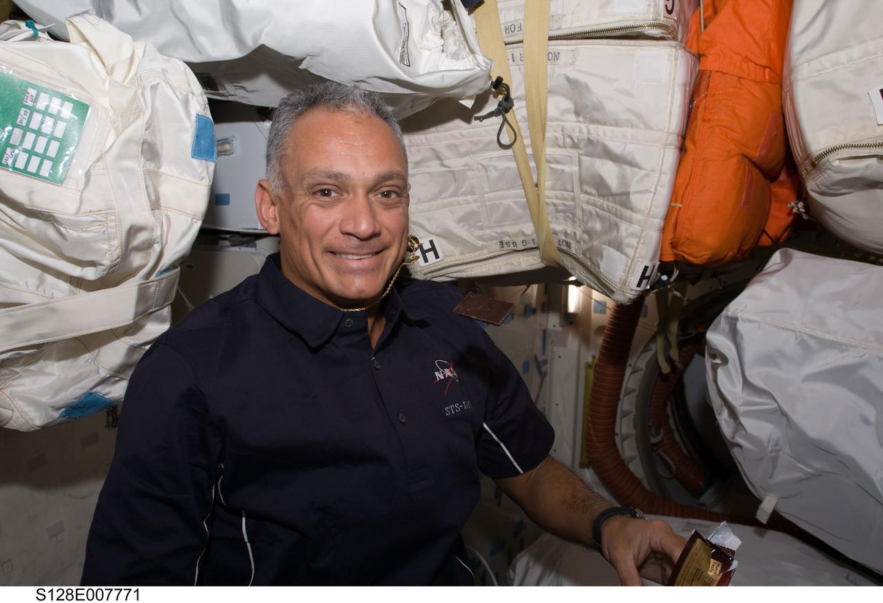 S128-E-007771 (6 Sept. 2009) --- NASA astronaut John “Danny” Olivas, STS-128 mission specialist, is pictured on the middeck of Space Shuttle Discovery with a floating piece of chocolate while docked with the International Space Station.
