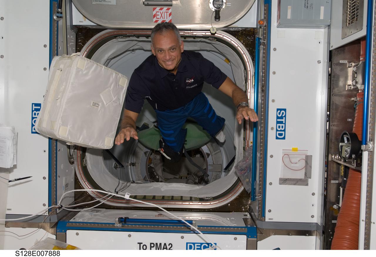 S128-E-007888 (6 Sept. 2009) --- NASA astronaut John “Danny” Olivas, STS-128 mission specialist, is pictured near a stowage bag floating freely in the Harmony node of the International Space Station while Space Shuttle Discovery remains docked with the station.