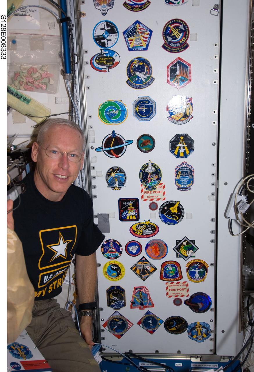 S128-E-008333 (7 Sept. 2009) --- NASA astronaut Patrick Forrester, STS-128 mission specialist, poses for a photo with the growing collection, in the Unity node, of insignias representing crews who have worked on the International Space Station.