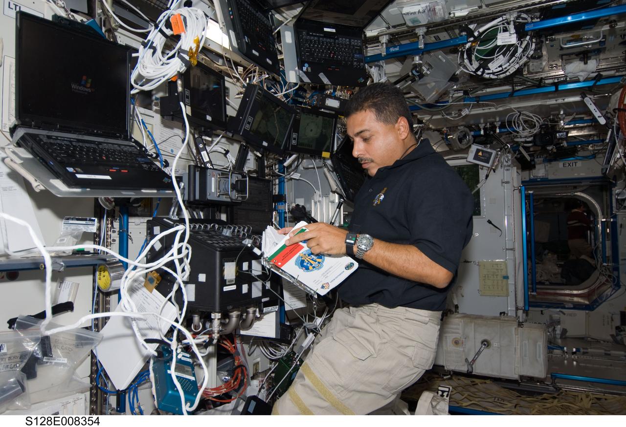 S128-E-008354 (7 Sept. 2009) --- NASA astronaut Jose Hernandez, STS-128 mission specialist, reads a procedures checklist in the Destiny laboratory of the International Space Station while Space Shuttle Discovery remains docked with the station.