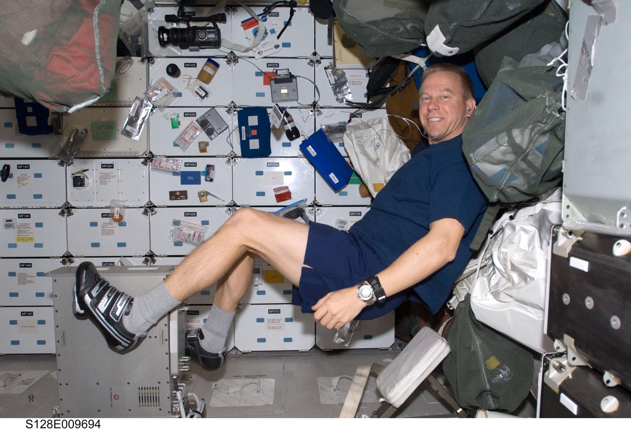 S128-E-009694 (8 Sept. 2009) --- NASA astronaut Tim Kopra, STS-128 mission specialist, exercises on a bicycle ergometer on the middeck of Space Shuttle Discovery during flight day 12 activities.