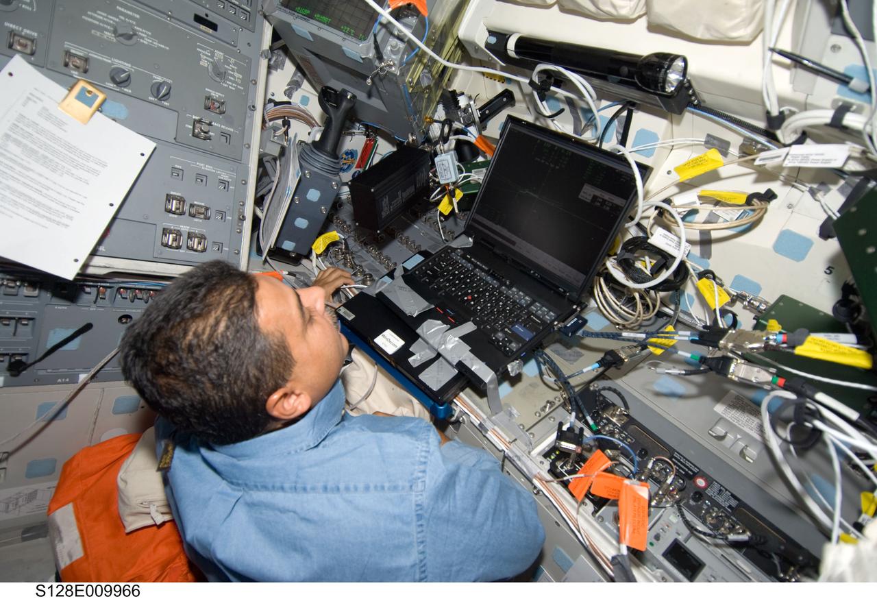 S128-E-009966 (8 Sept. 2009) --- NASA astronaut Jose Hernandez, STS-128 mission specialist, uses a computer on the aft flight deck of Space Shuttle Discovery during flight day 12 activities.