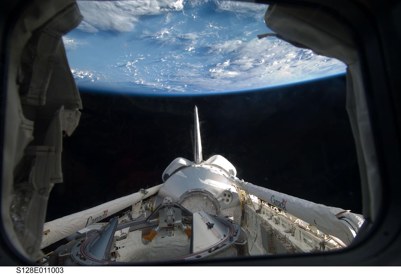 S128-E-011003 (9 Sept. 2009) --- Backdropped by Earth's horizon and the blackness of space, the Leonardo Multi-Purpose Logistics Module visible in Space Shuttle Discovery's payload bay, docking mechanism, vertical stabilizer, orbital maneuvering system (OMS) pods and Remote Manipulator System/Orbiter Boom Sensor System (RMS/OBSS) are featured in this image photographed by an STS-128 crew member from an aft flight deck window.